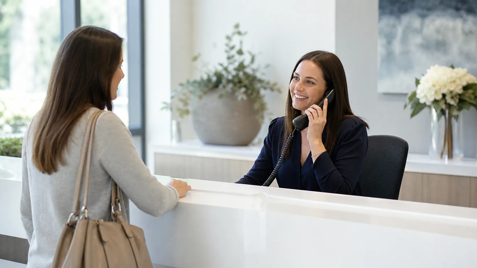 A clinic receptionist speaking on the phone while helping a patient